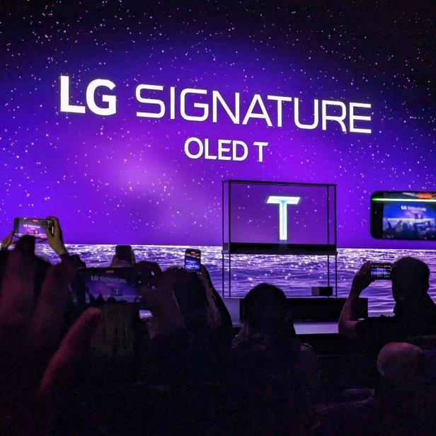 Zuschauer filmen die Präsentation des LG Signature OLED T Fernsehers.