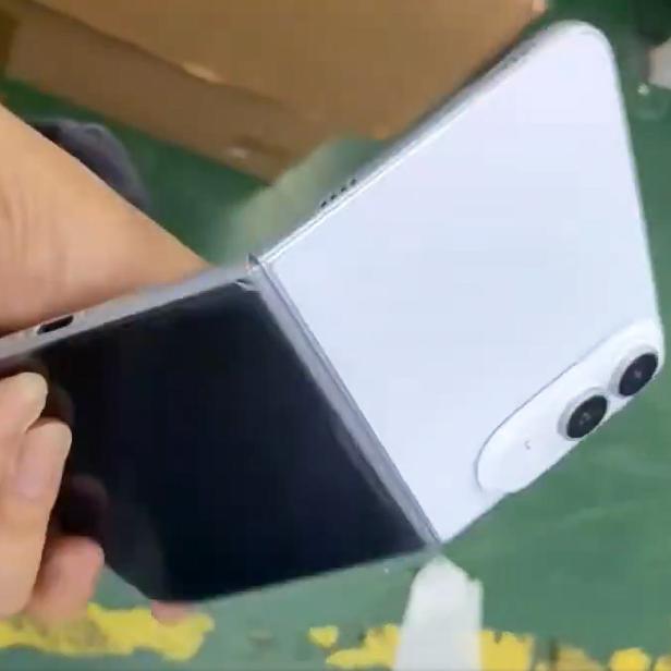 Eine Hand hält ein klappbares Smartphone mit weißer Rückseite