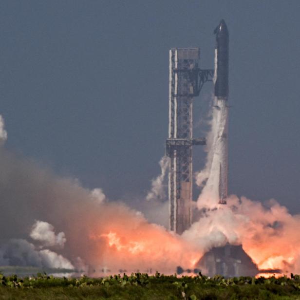 Die SpaceX Starship-Rakete hebt von der Startrampe ab, umgeben von einer riesigen Rauch- und Feuerwolke.