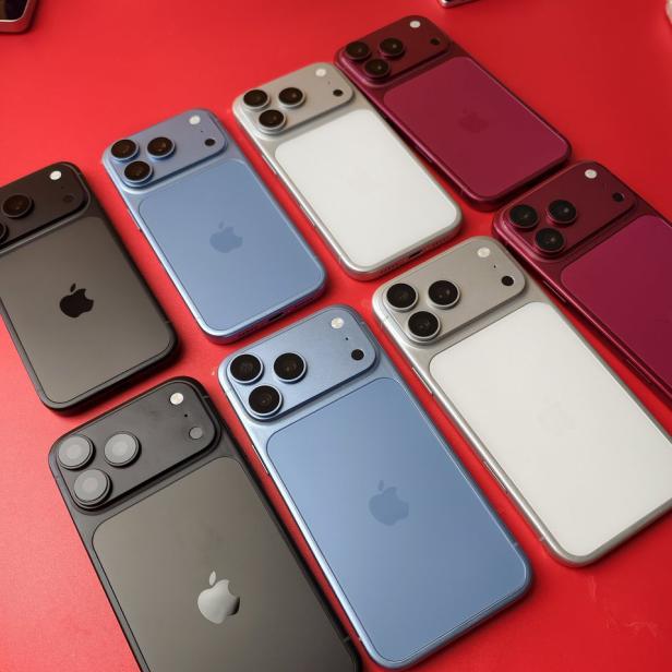 Mehrere iPhone-Dummys in Schwarz, Hellblau, Silber und Dunkelrot auf rotem Untergrund.