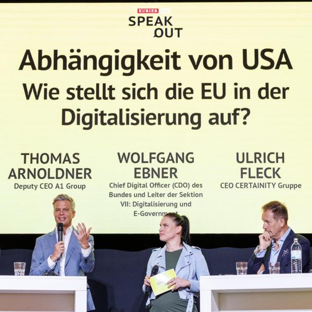 Vier Personen diskutieren auf einer Bühne vor einer großen Tafel mit dem Thema „Abhängigkeit von USA in der Digitalisierung“.