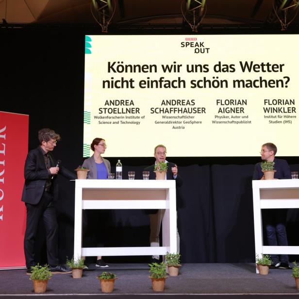 Fünf Personen diskutieren auf einer Bühne vor einer großen Leinwand mit der Frage „Können wir uns das Wetter nicht einfach schön machen?“.