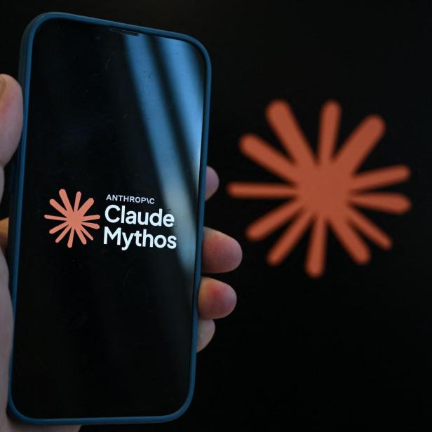 Eine Hand hält ein Smartphone, auf dessen Display das Logo von Anthropic sowie der Schriftzug „Claude Mythos“ vor einem schwarzen Hintergrund zu sehen sind.
