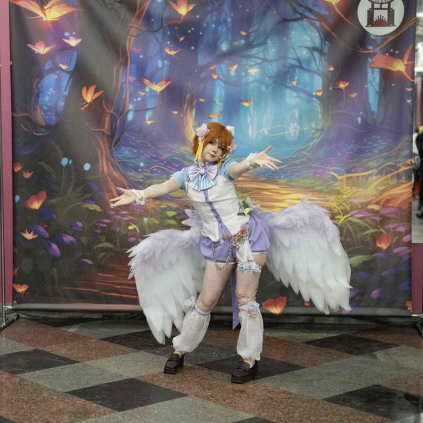 Cosplayerin vor buntem Hintergrund. (Symbolbild)