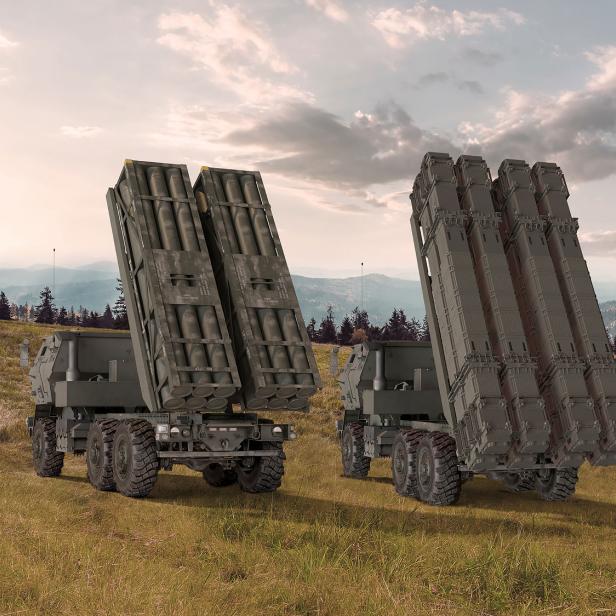 3 Raketenartillerie-Fahrzeue des Typs HIMARS stehen in einer Graslandschaft