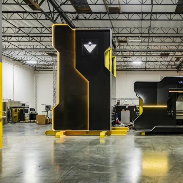 Zwei schwarze Modulcontainer in einer Industriehalle, einer mit Valar-Atomics-Logo.