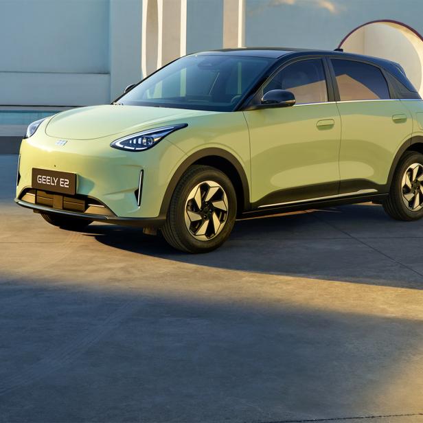 Geely E2 in Hellgrün vor moderner Architektur.