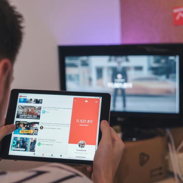Mann hat YouTube auf 2 Bildschirmen geöffnet