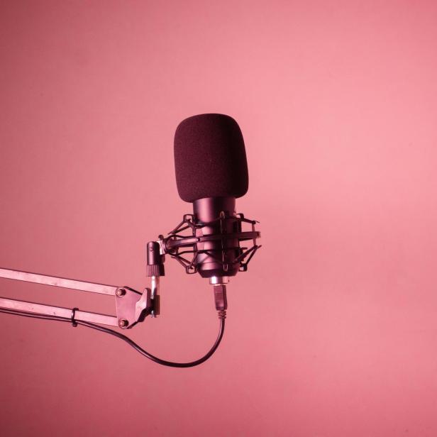 Podcast-Mirko vor rotem Hintergrund. 