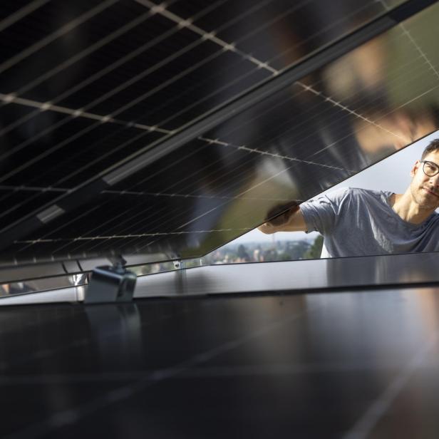 Ein Mann klappt ein Solarzpaneel auf 