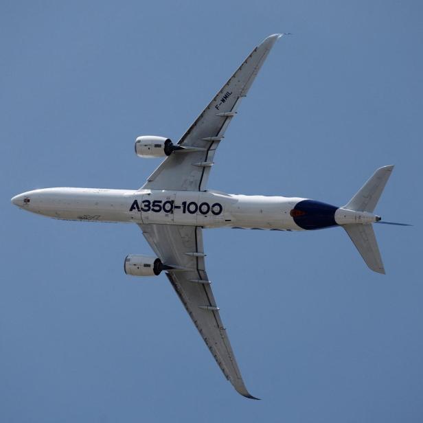Ein Airbus A350-1000 fliegt mit ausgefahrenem Fahrwerk vor klarem blauen Himmel.