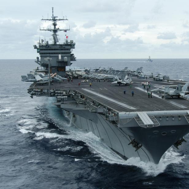 Flugzeugträger USS Enterprise auf hoher See mit Jets auf dem Deck.