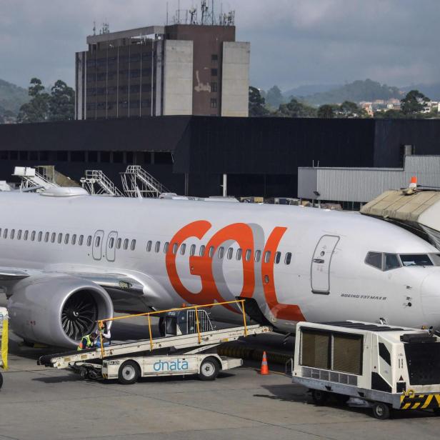 Passagierflugzeug von Gol auf dem Vorfeld, umgeben von Gepäckwagen und Wartungspersonal.