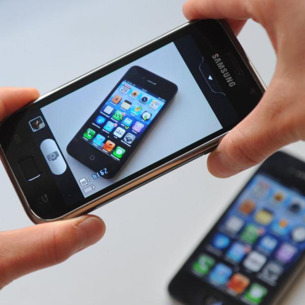 Eine Person fotografiert mit einem Samsung-Smartphone ein anderes Smartphone.