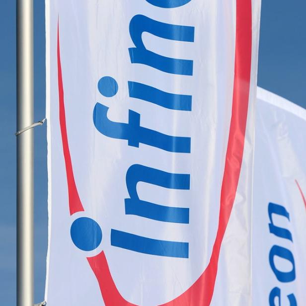 Eine Infineon-Flagge weht vor blauem Himmel.